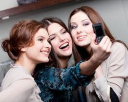 three women smiling and taking a picture
