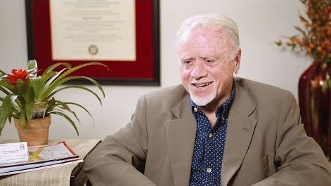 a man wearing a suit jacket smiling