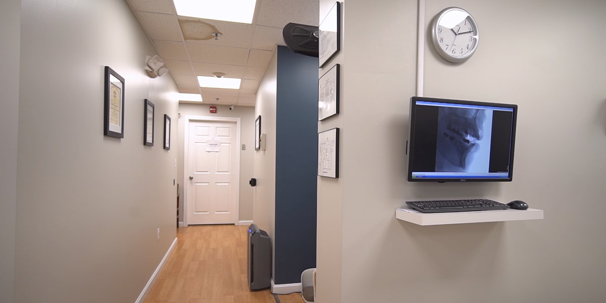 hallway in dental office with wood floors and beige and navy walls