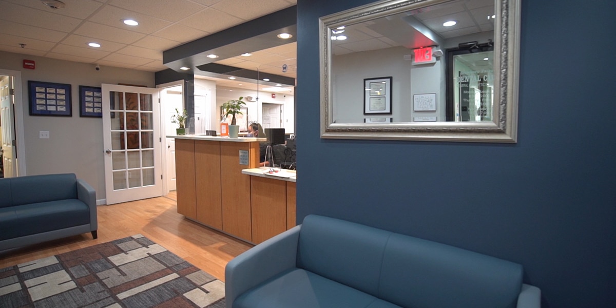 dental reception desk and waiting room with navy couches