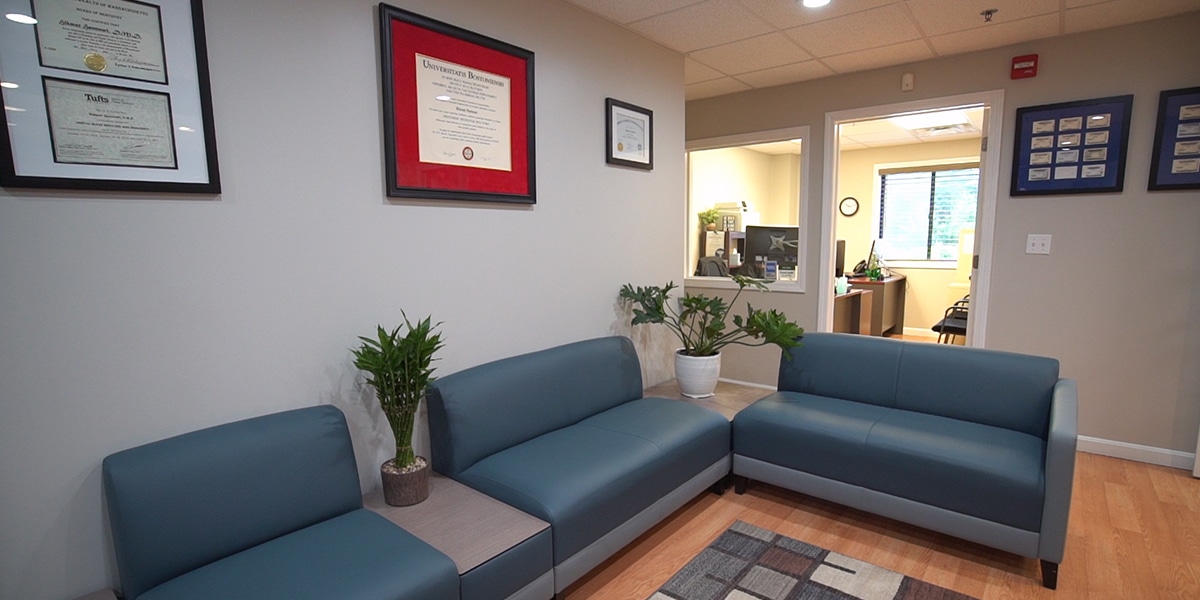 dental office reception area with degrees hanging on wall