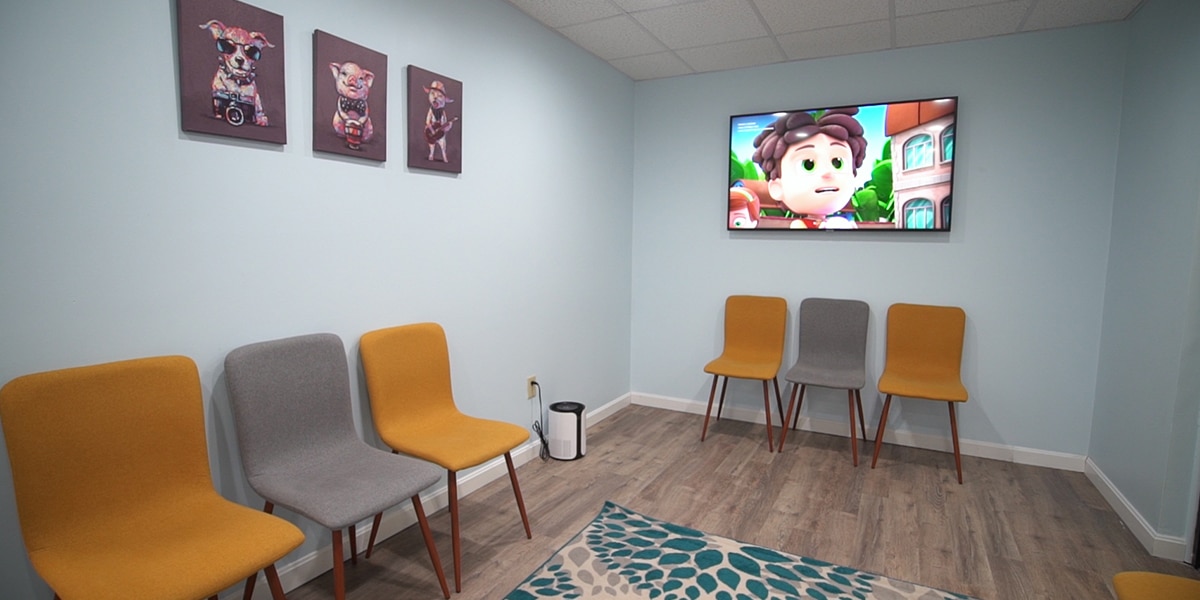 waiting room with yellow and grey fabric chairs and light blue walls