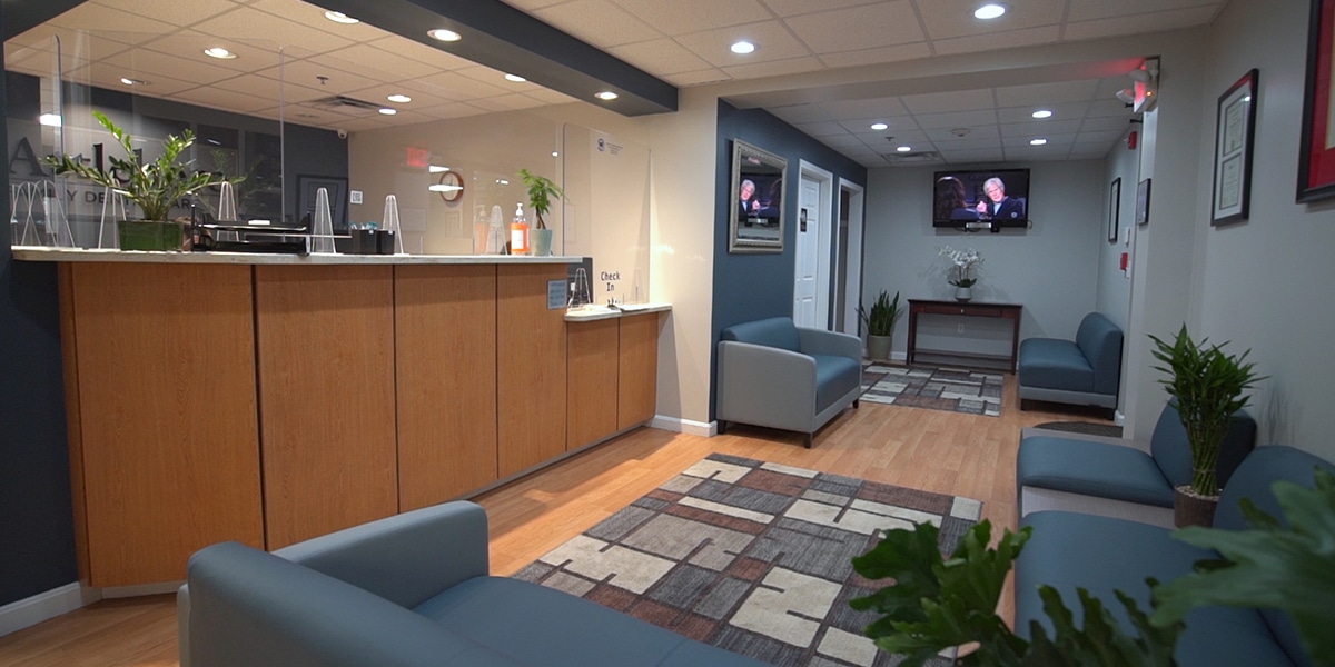 dental office waiting room with navy couches and flat screen TV on wall