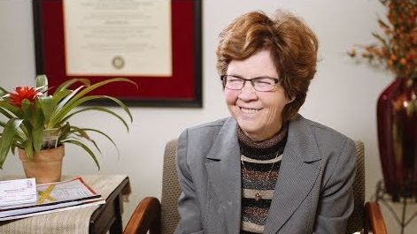 a woman with glasses smiling