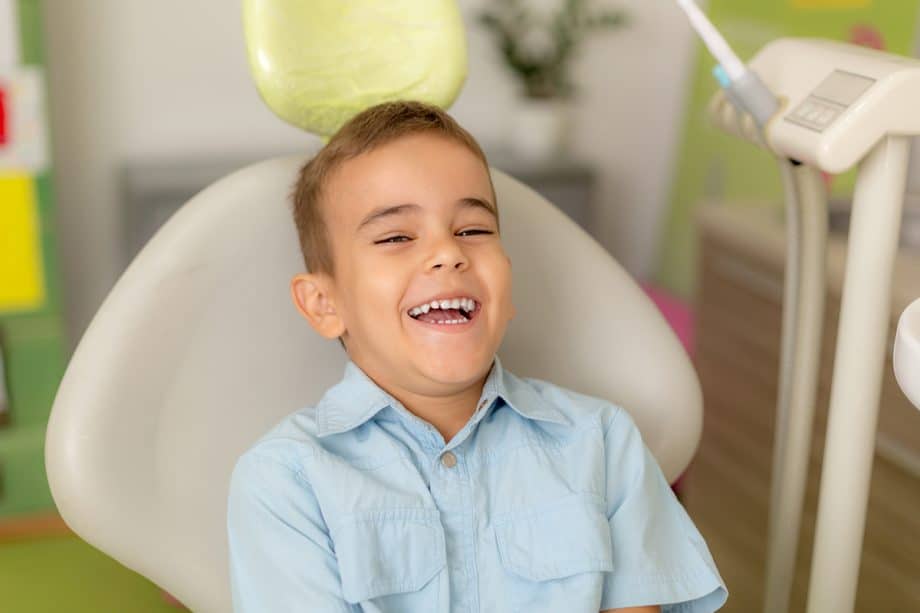 Young boy smiling in dental exam room chair